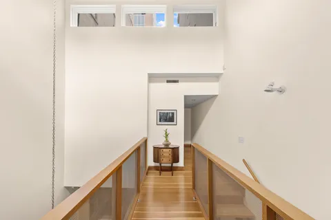 a spacious bedroom with a bed and wooden floor