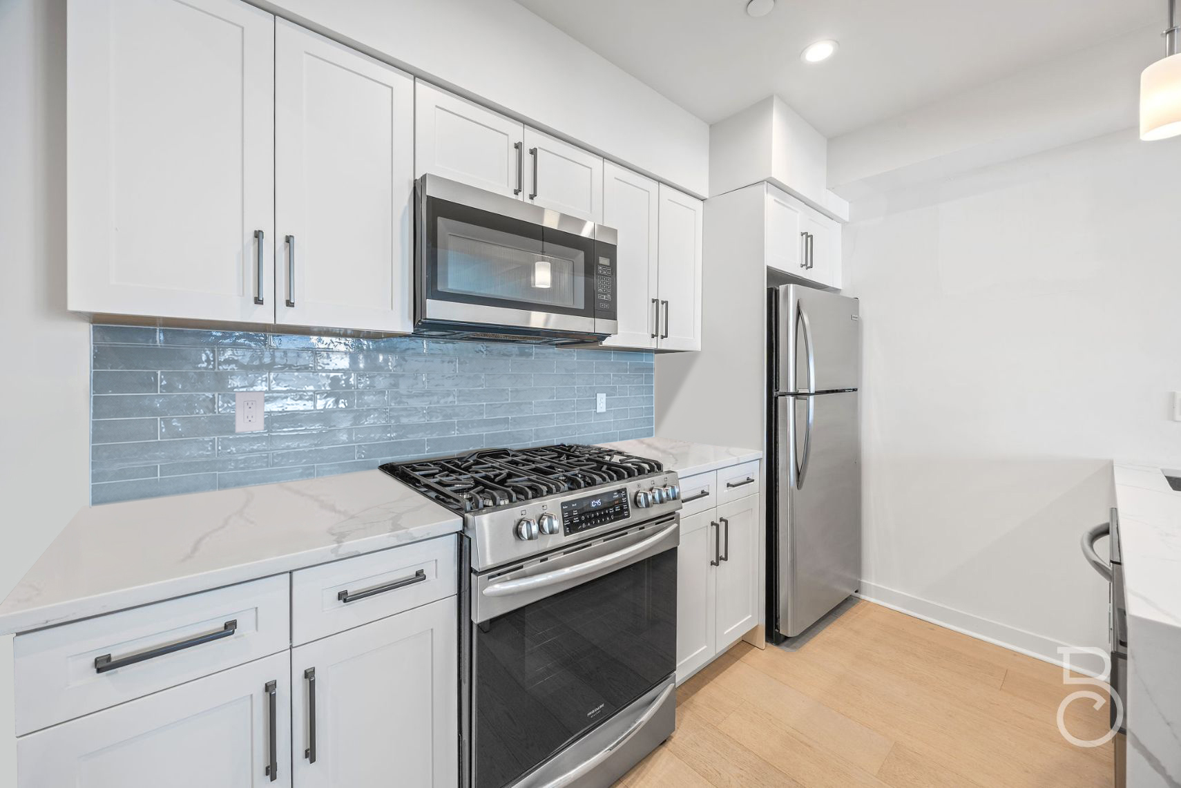 25-74 34th Street, Unit 4C Queens, NY 11103 - Photo 2 of 15 a kitchen with white cabinets and stainless steel appliances