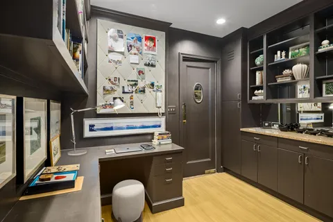 a room with stainless steel appliances kitchen island granite countertop a refrigerator and a sink