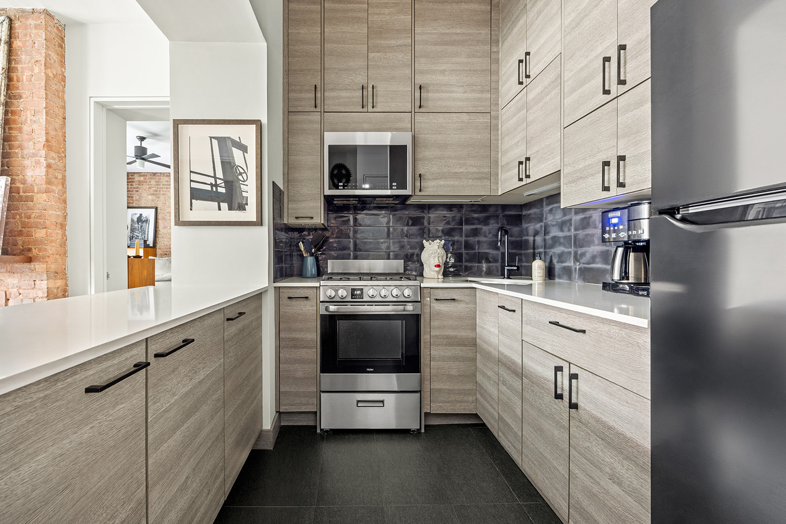 360 West 21st Street, Unit 2DE Manhattan, NY 10011 - Photo 3 of 9 a kitchen with stainless steel appliances a stove microwave and cabinets