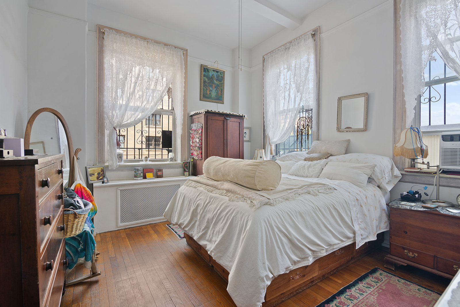 41 Eastern Parkway, Unit 1D Brooklyn, NY 11238 - Photo 10 of 16 a bedroom with a bed and a large window with wooden floor