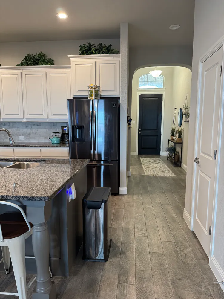 a kitchen with granite countertop a sink and a refrigerator