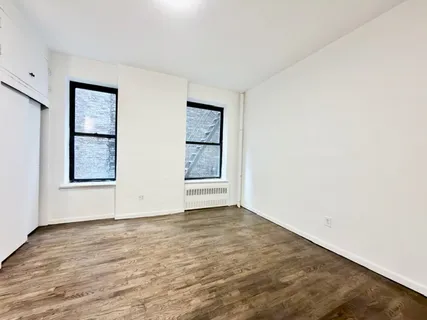 an empty room with windows and closet