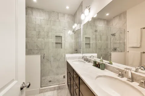 a bathroom with a granite countertop sink mirror and shower