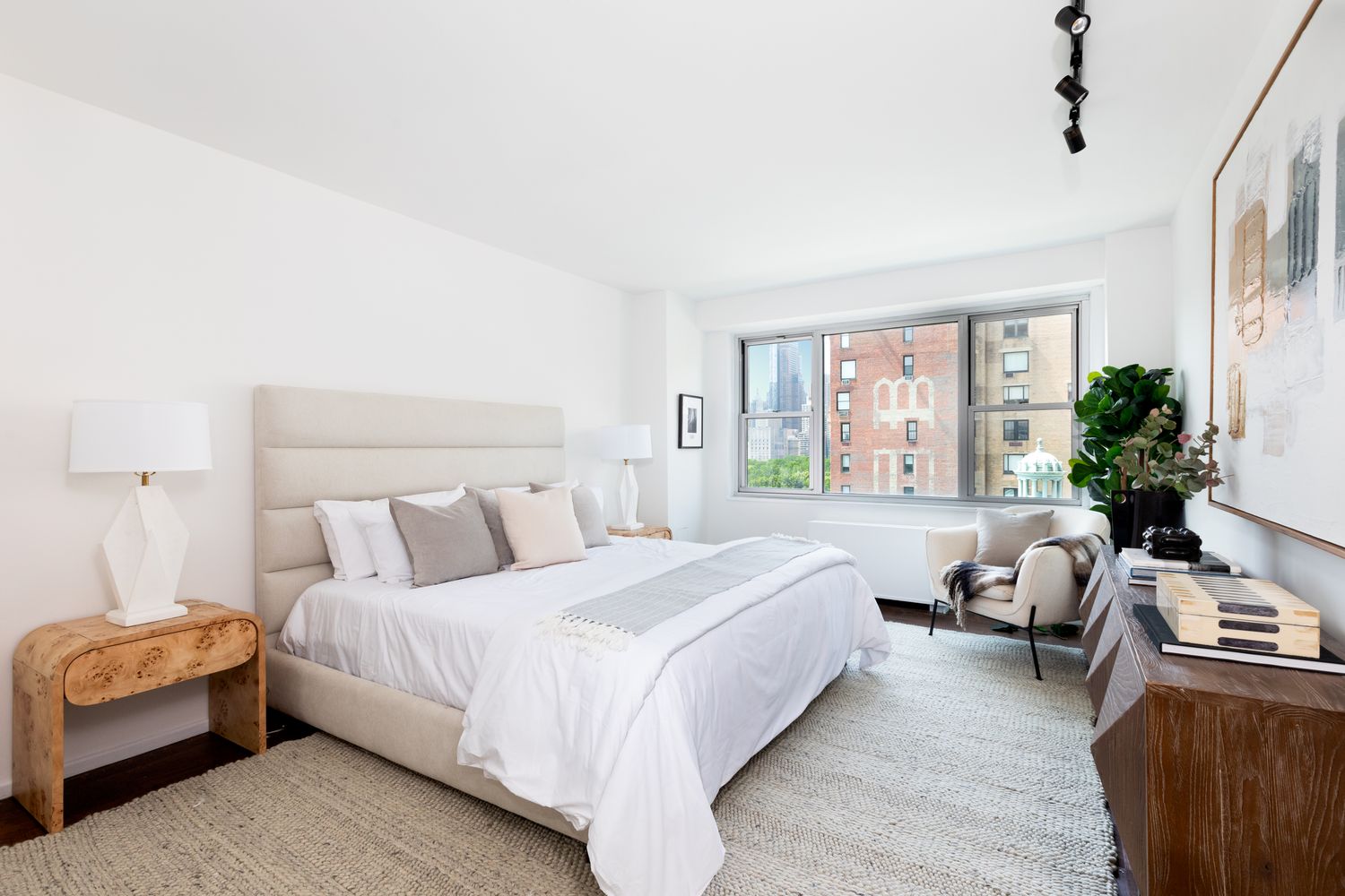 a bedroom with a bed couch and windows