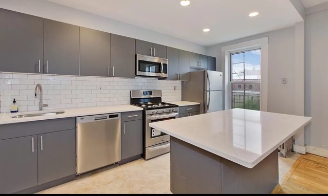 a kitchen with stainless steel appliances a microwave sink and refrigerator
