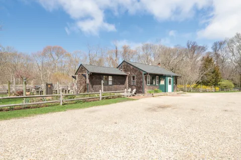 a view of a house with a yard and large trees