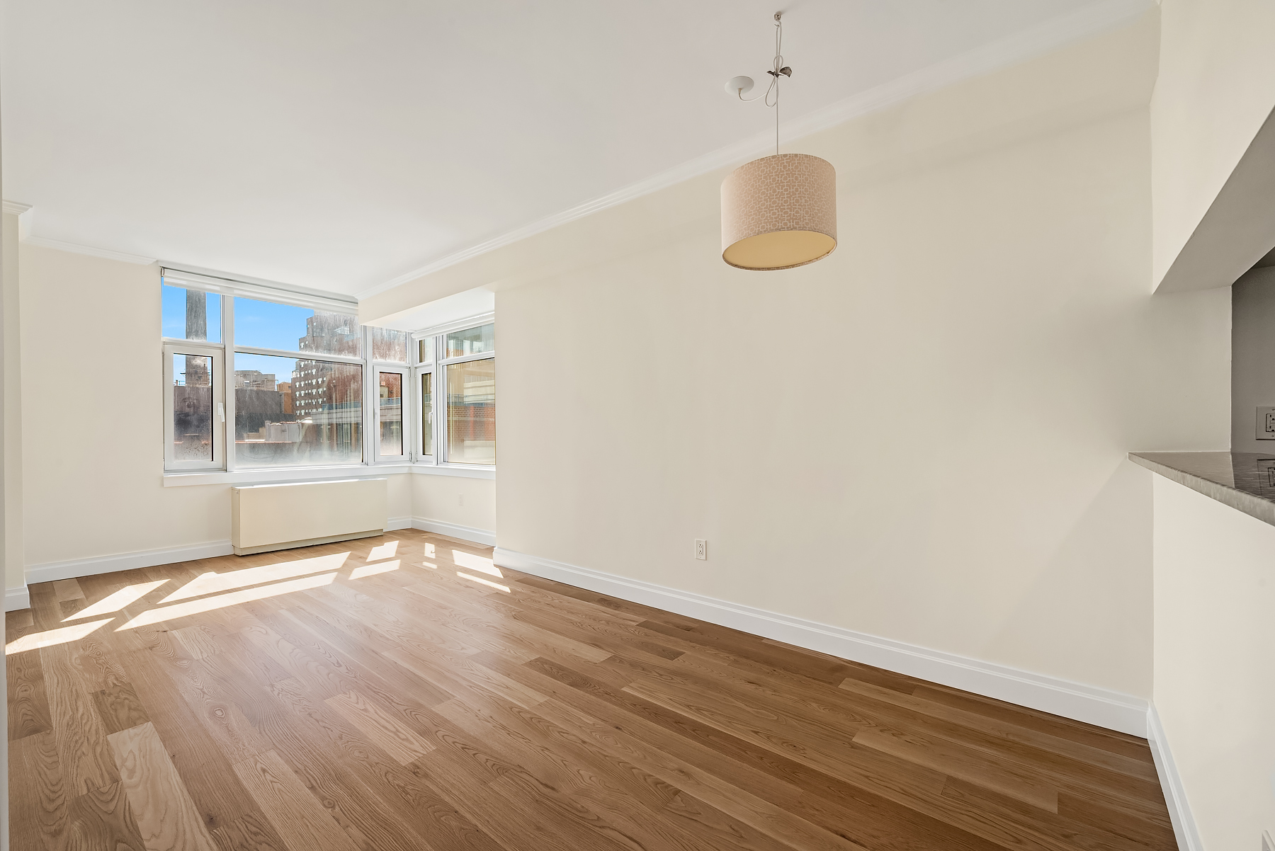 404 East 76th Street, Unit 7C Manhattan, NY 10021 - Photo 2 of 13 a view of an empty room with wooden floor and a window