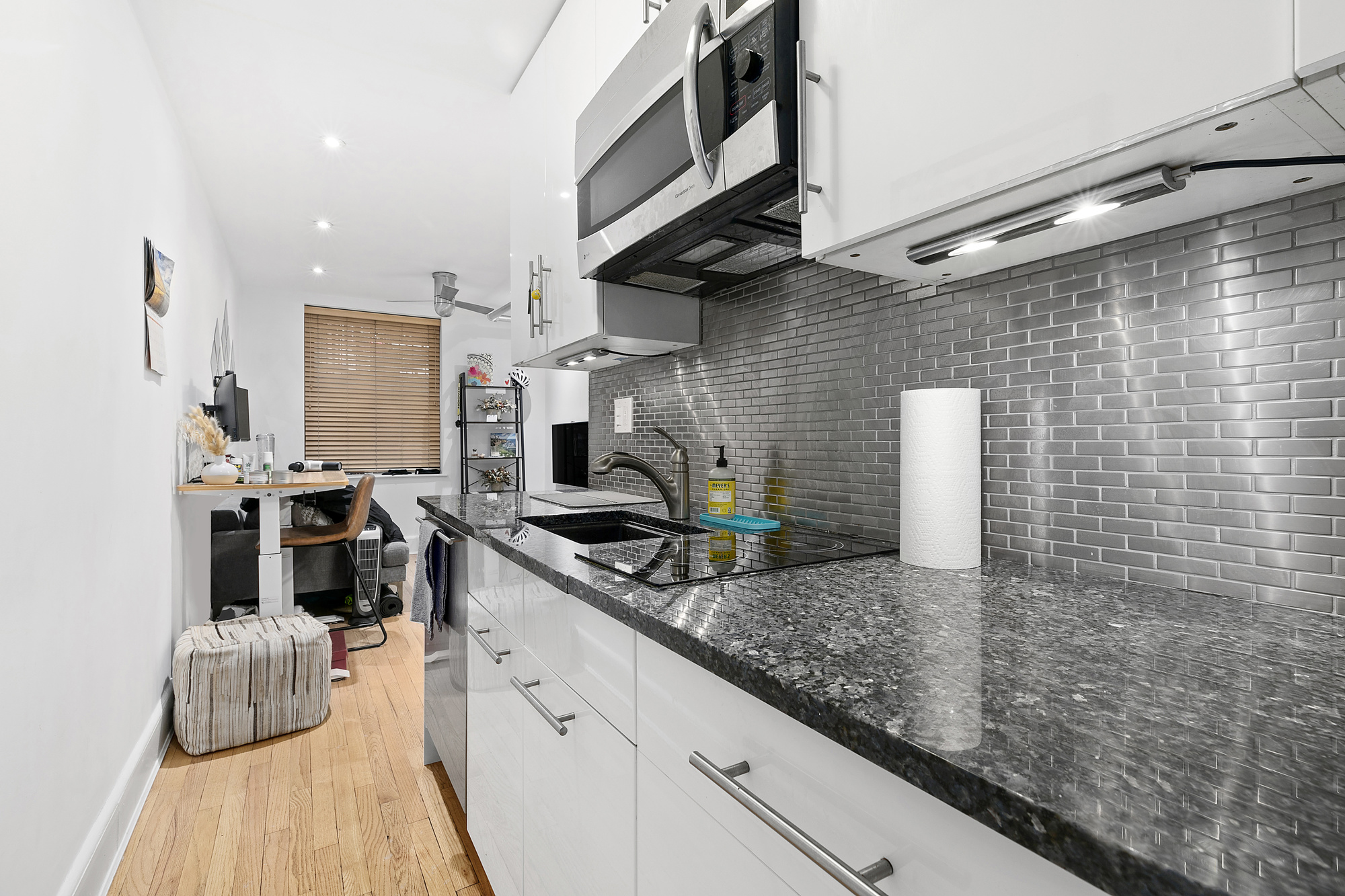 140 West 10th Street, Unit BTW Manhattan, NY 10014 - Photo 3 of 8 a kitchen with stainless steel appliances granite countertop a sink a stove and cabinets