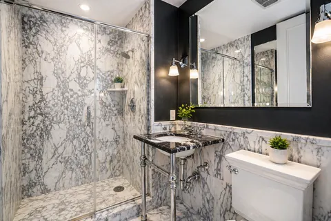 a bathroom with a granite countertop sink a toilet and shower