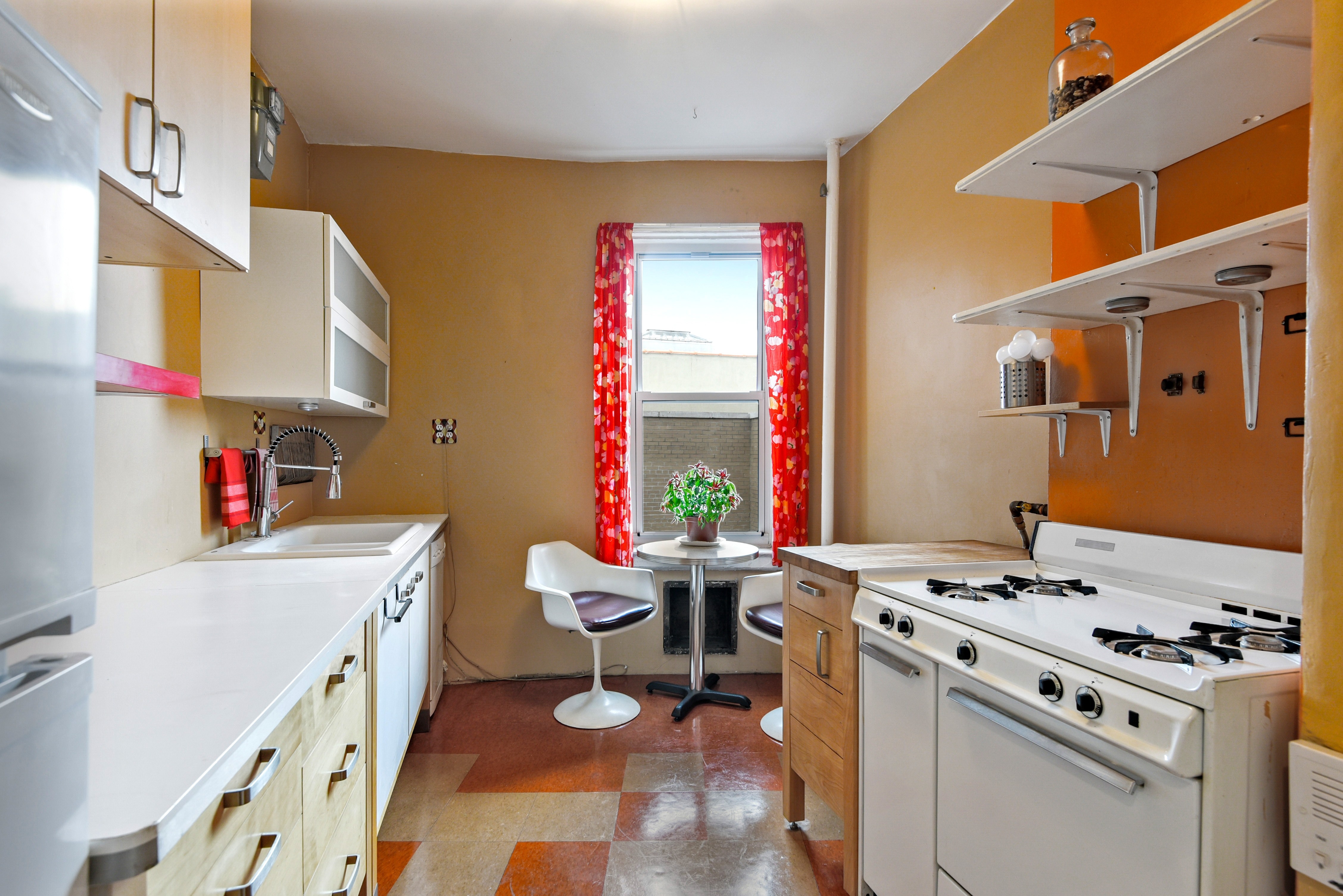 720 West 173rd Street, Unit 59 Manhattan, NY 10032 - Photo 4 of 9 a kitchen that has a stove and a table in it