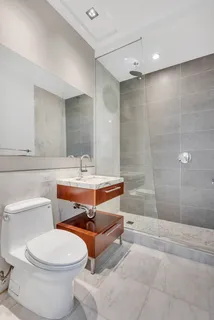a bathroom with a toilet a sink a mirror and a bathtub