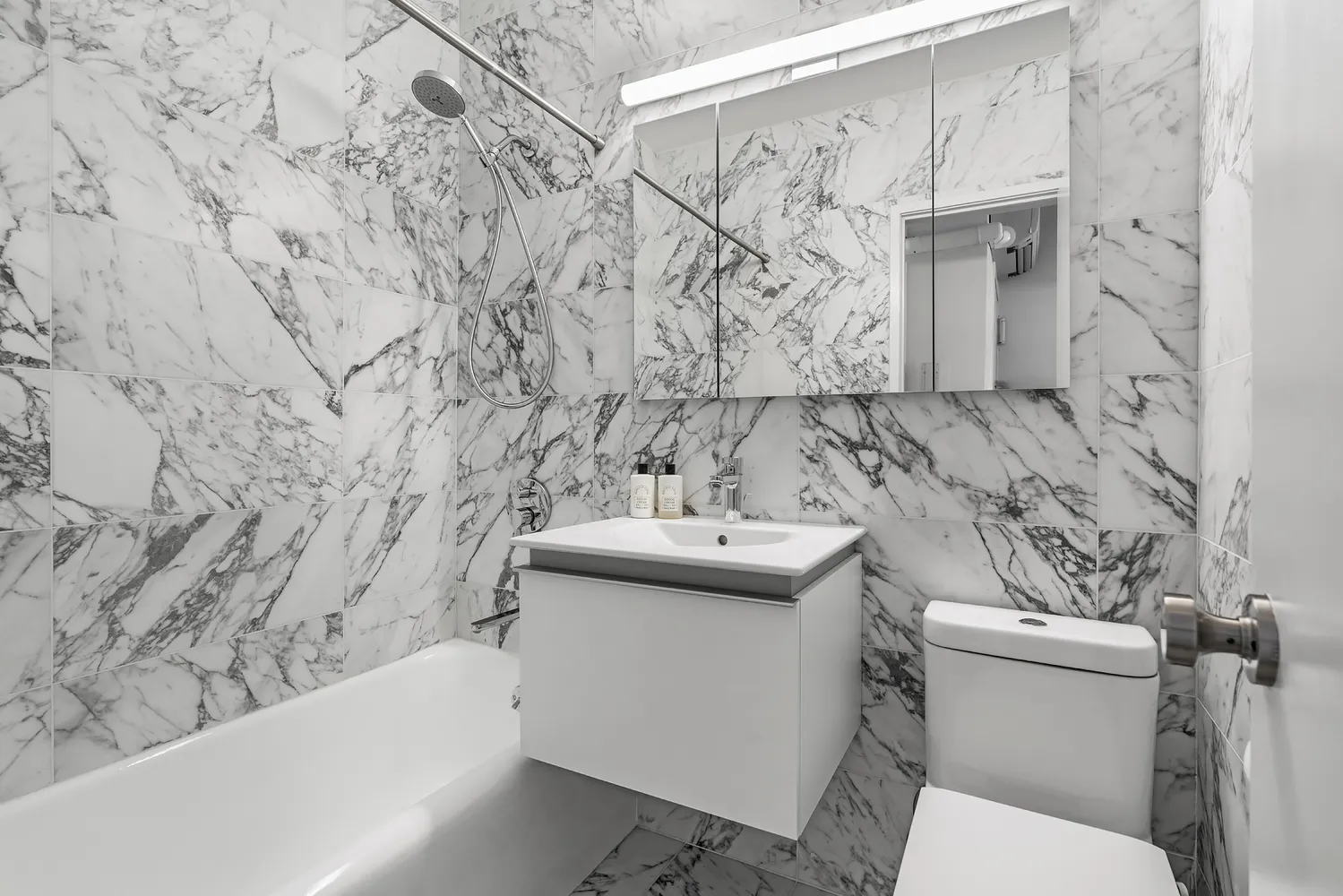 a bathroom with a sink and mirror with toilet