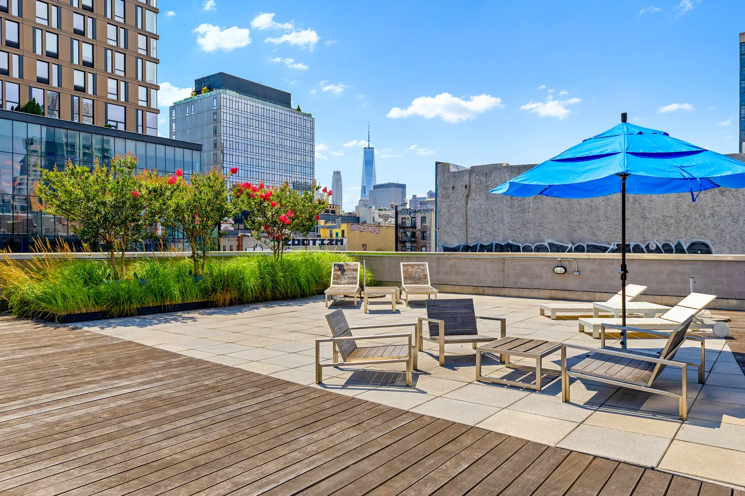 a view of a rooftop with chairs and umbrella in the patio