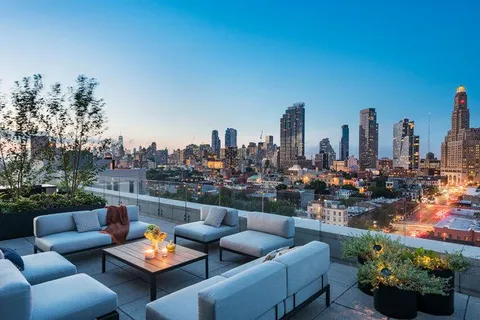 a view of a roof deck with couches and potted plants