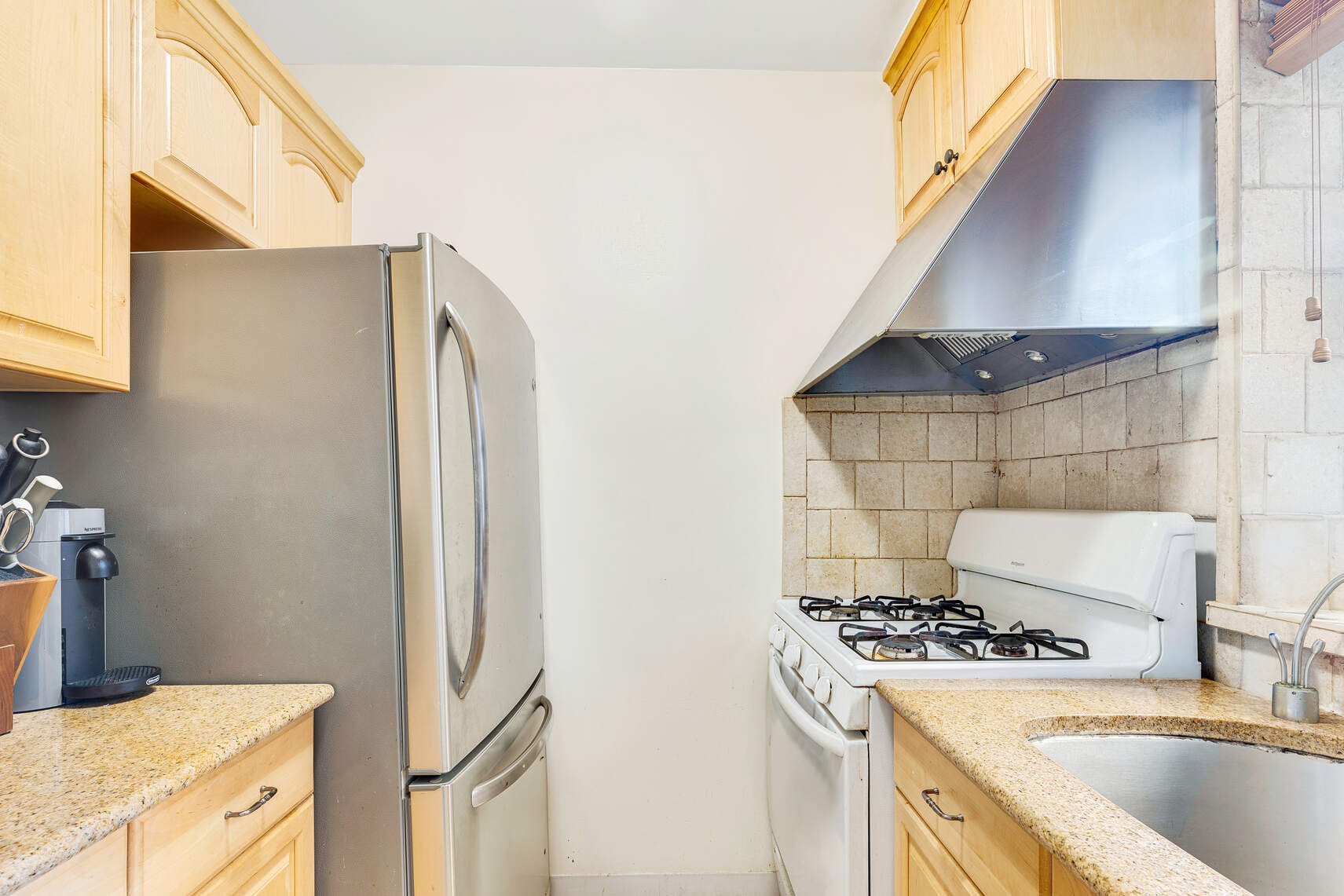 159 West 53rd Street, Unit 18B Manhattan, NY 10019 - Photo 4 of 11 a kitchen with a sink stove and refrigerator