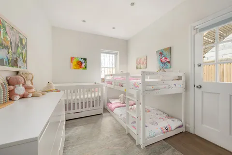 a bedroom with baby bed and a window