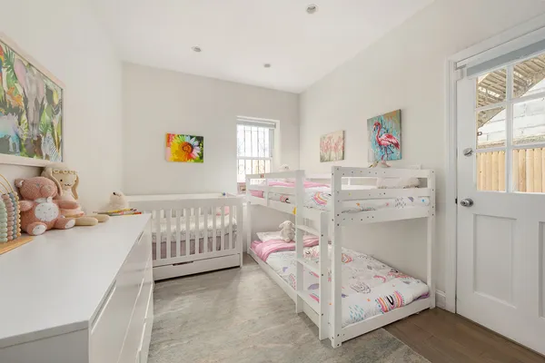 a bedroom with baby bed and a window
