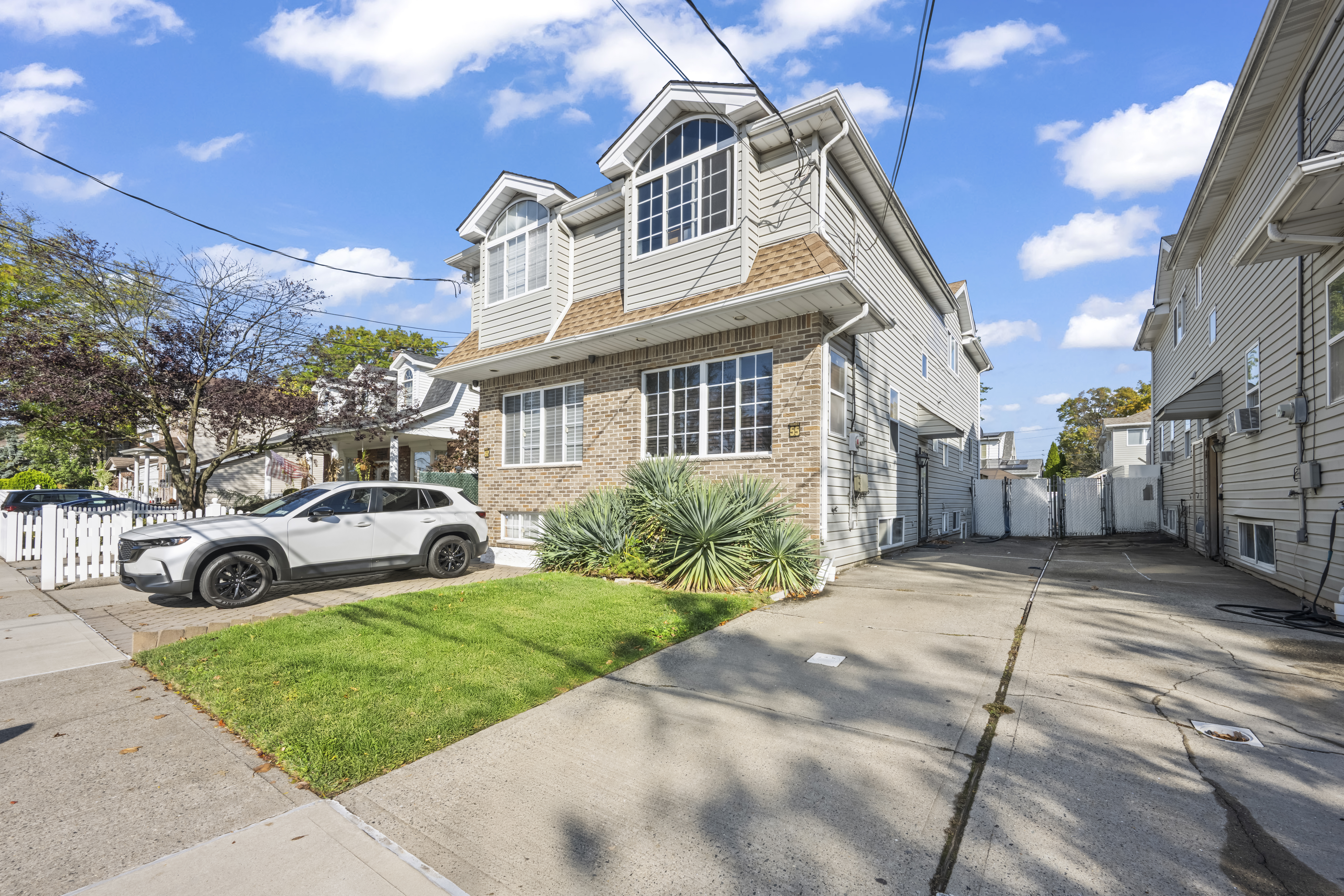 55 Sideview Avenue Staten Island, NY 10314 - Photo 2 of 28 a view of a white house with a small yard and large trees
