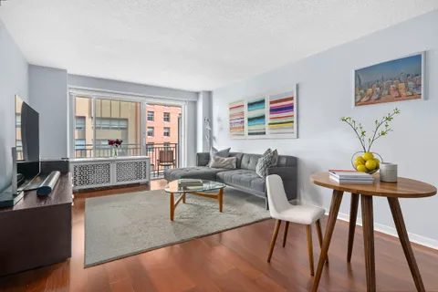 a living room with furniture a flat screen tv and a window