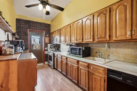 a kitchen with stainless steel appliances granite countertop a sink a stove cabinets counter space and a window