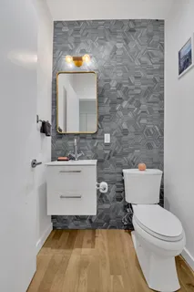 a bathroom with a sink a toilet and mirror
