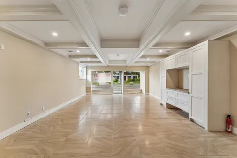 an empty room with windows and fireplace
