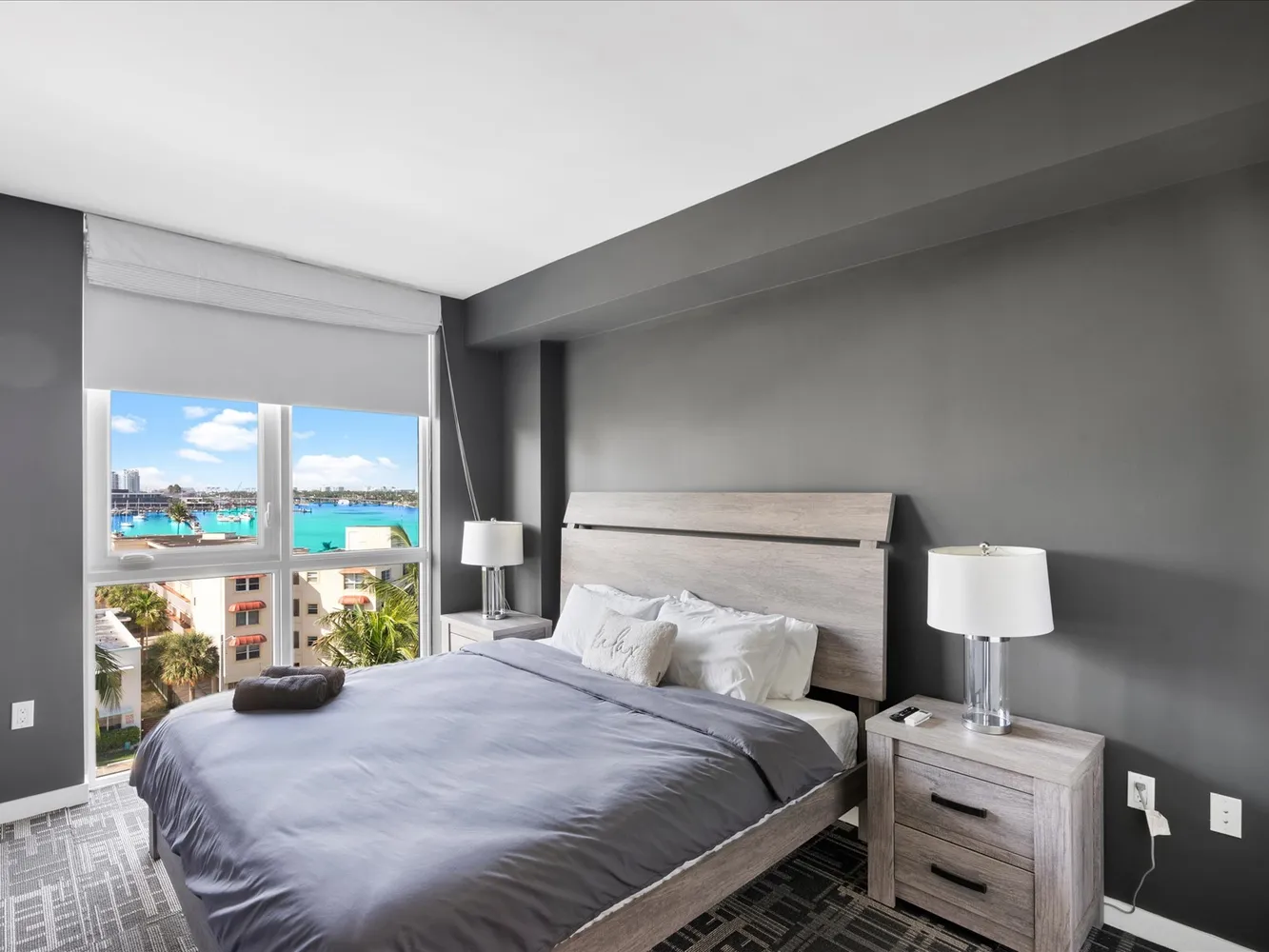 a bedroom with a bed and large windows