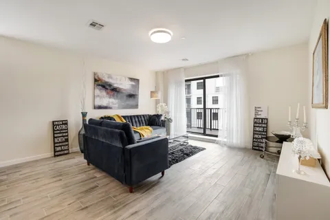 a living room with furniture and a wooden floor