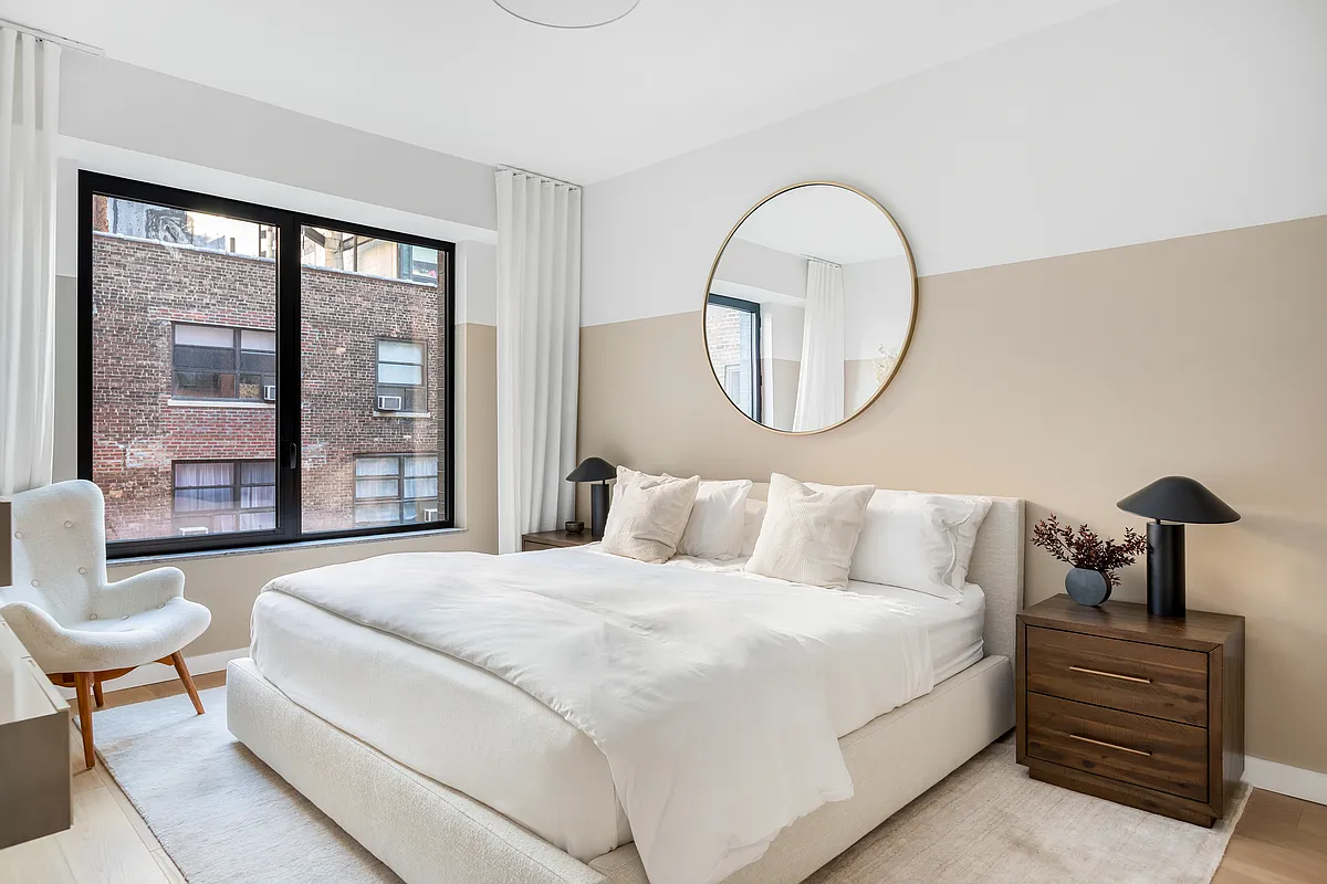 139 East 23rd Street, Unit 7 Manhattan, NY 10010 - Photo 7 of 17 a bedroom with a bed a couch and a large window