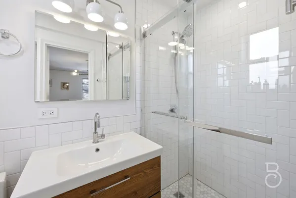 a bathroom with a sink a large mirror and shower
