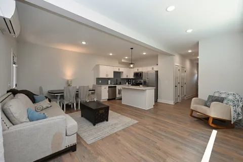 a living room with furniture and kitchen view