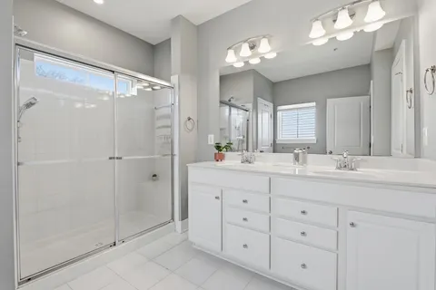 a bathroom with a shower sink and mirror