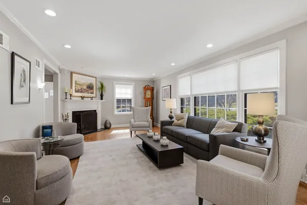 a living room with furniture a large window and a fireplace