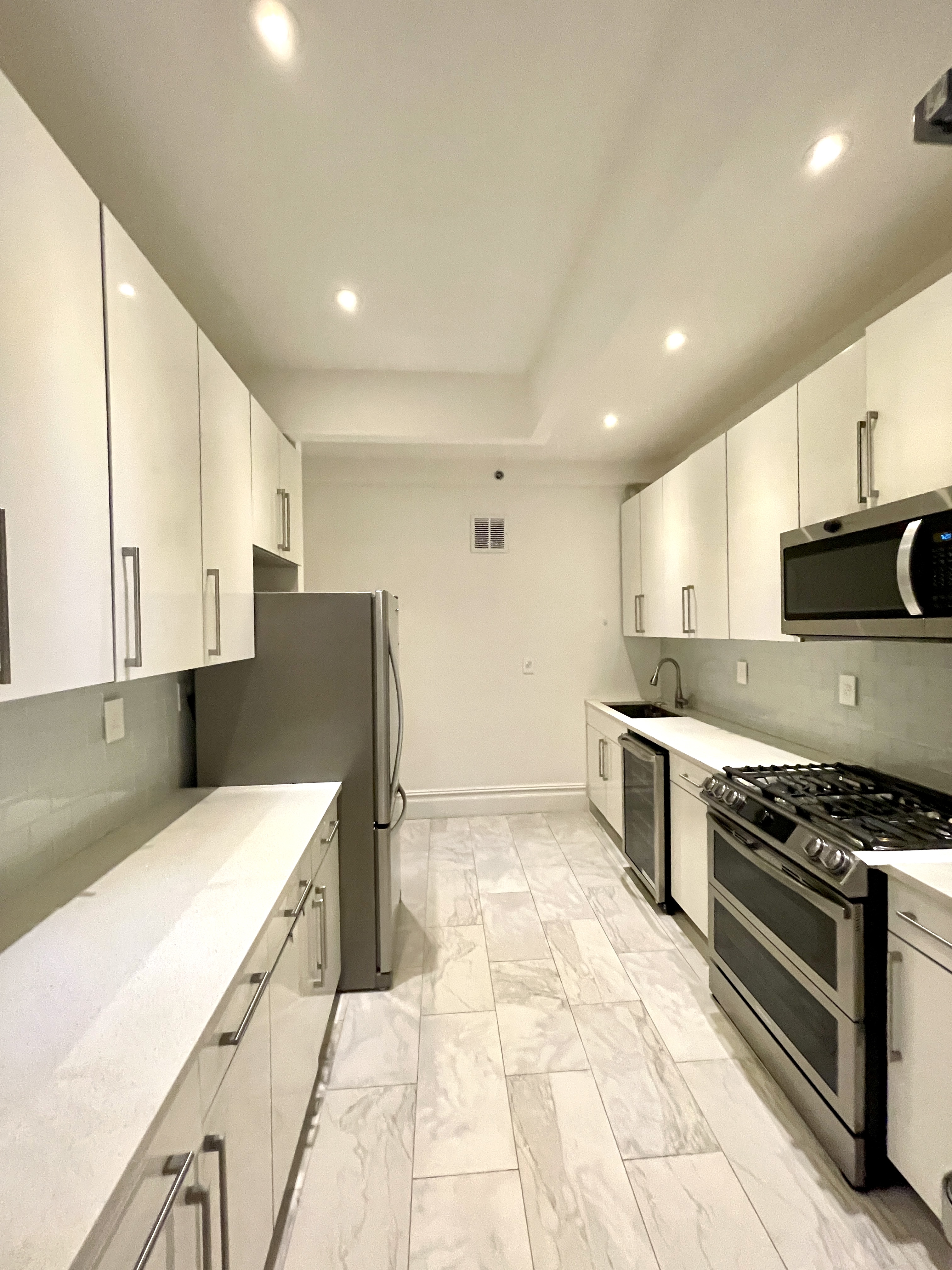 203 West 90th Street, Unit 6B Manhattan, NY 10024 - Photo 5 of 22 a kitchen with stainless steel appliances kitchen island granite countertop a sink and cabinets