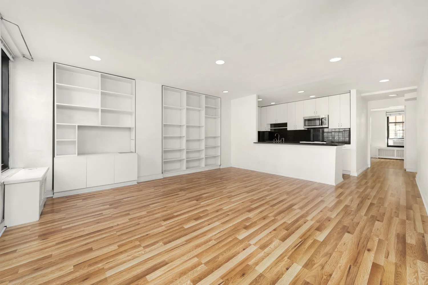 a view of a kitchen with wooden floor and a refrigerator