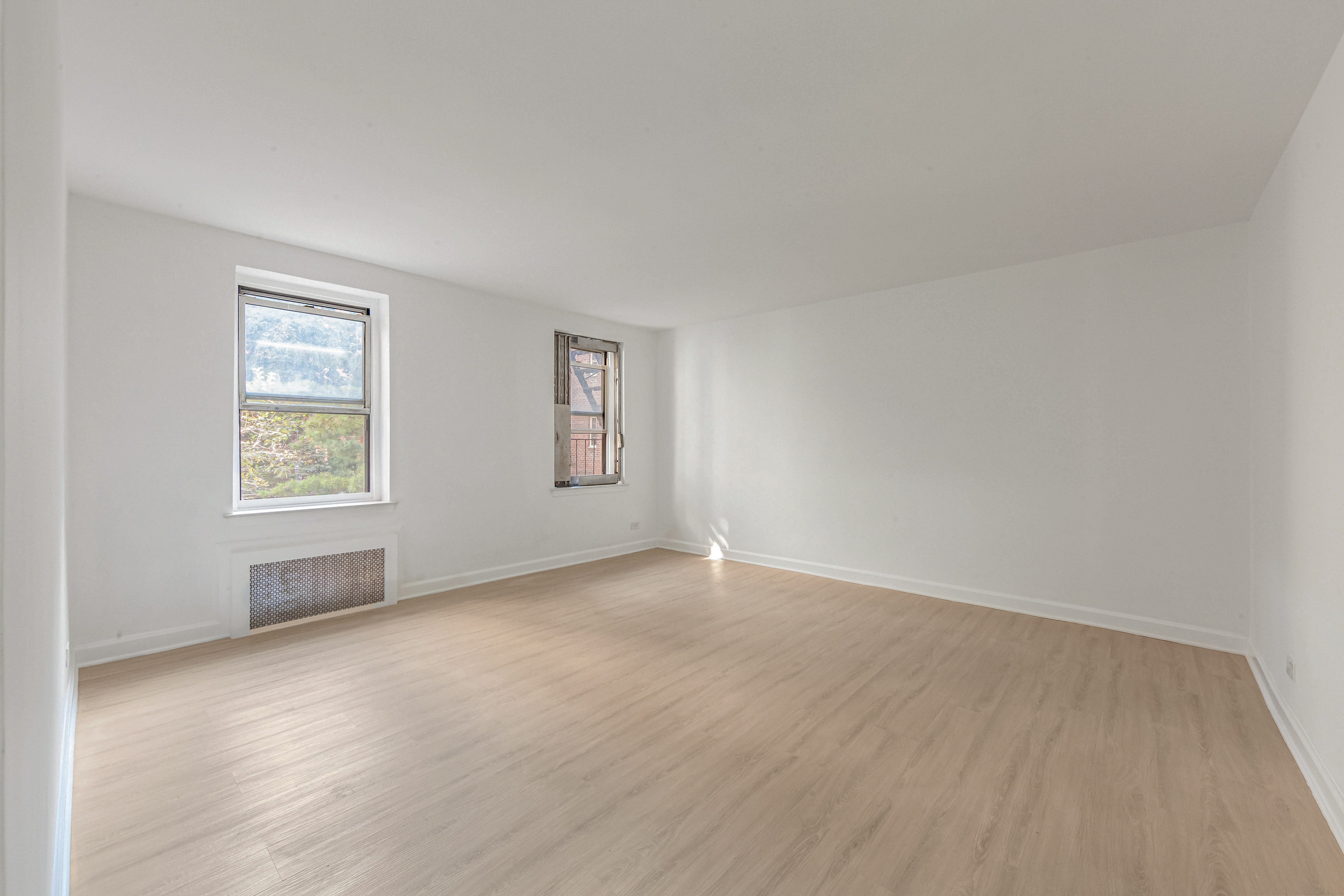 76-10 34th Avenue, Unit 2H Queens, NY 11372 - Photo 2 of 12 an empty room with windows
