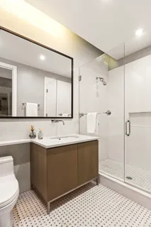 a bathroom with a sink a toilet and shower