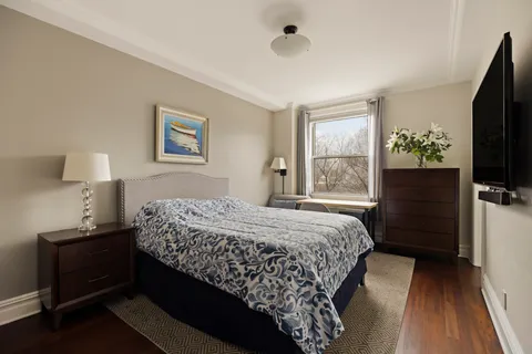 a bedroom with a bed and a flat tv screen on a dresser