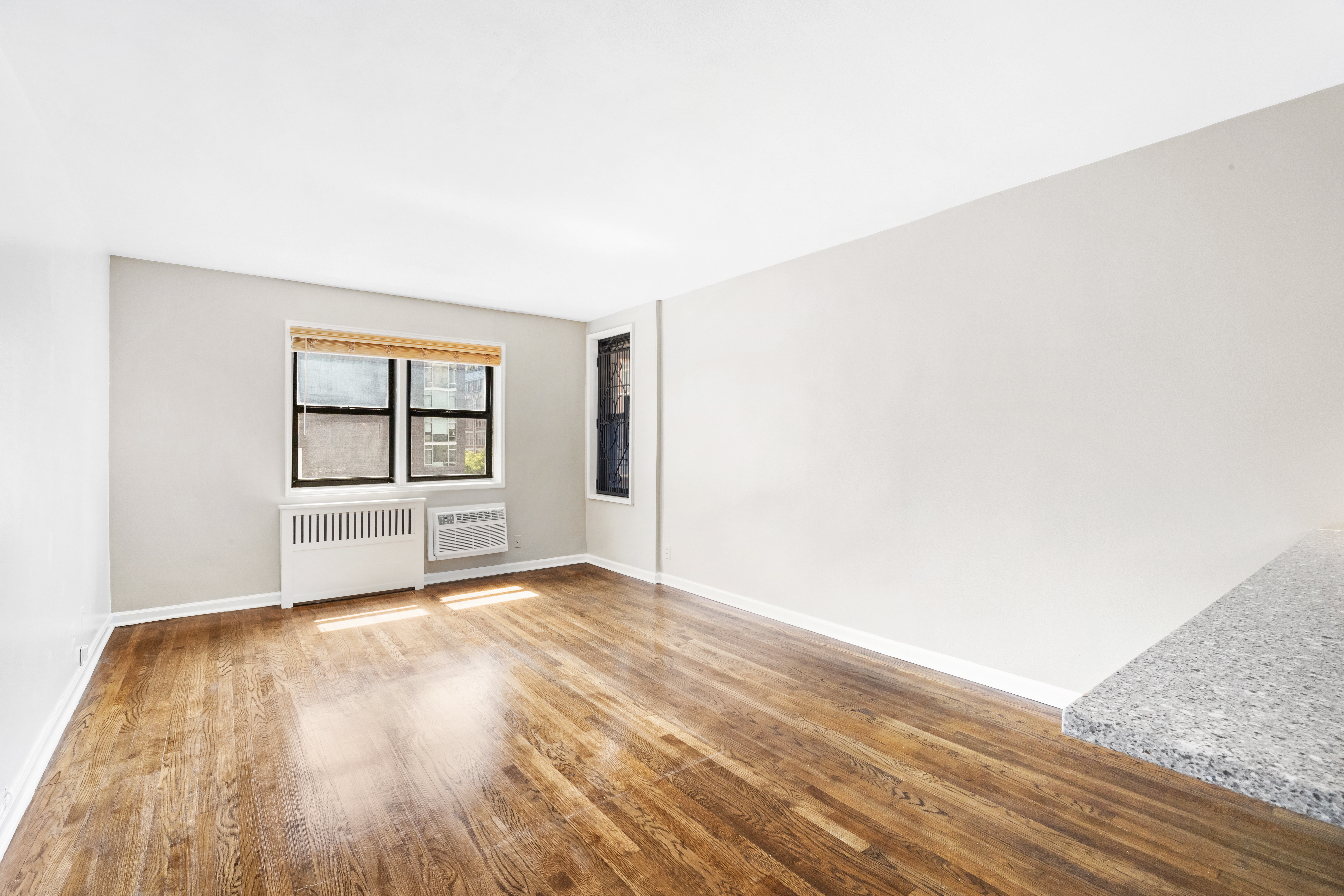 140 7th Avenue, Unit 4J Manhattan, NY 10011 - Photo 2 of 8 a view of an empty room with window and wooden floor
