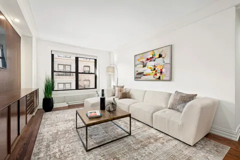 a living room with furniture a rug and a window