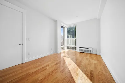 a view of a room with wooden floor and a window