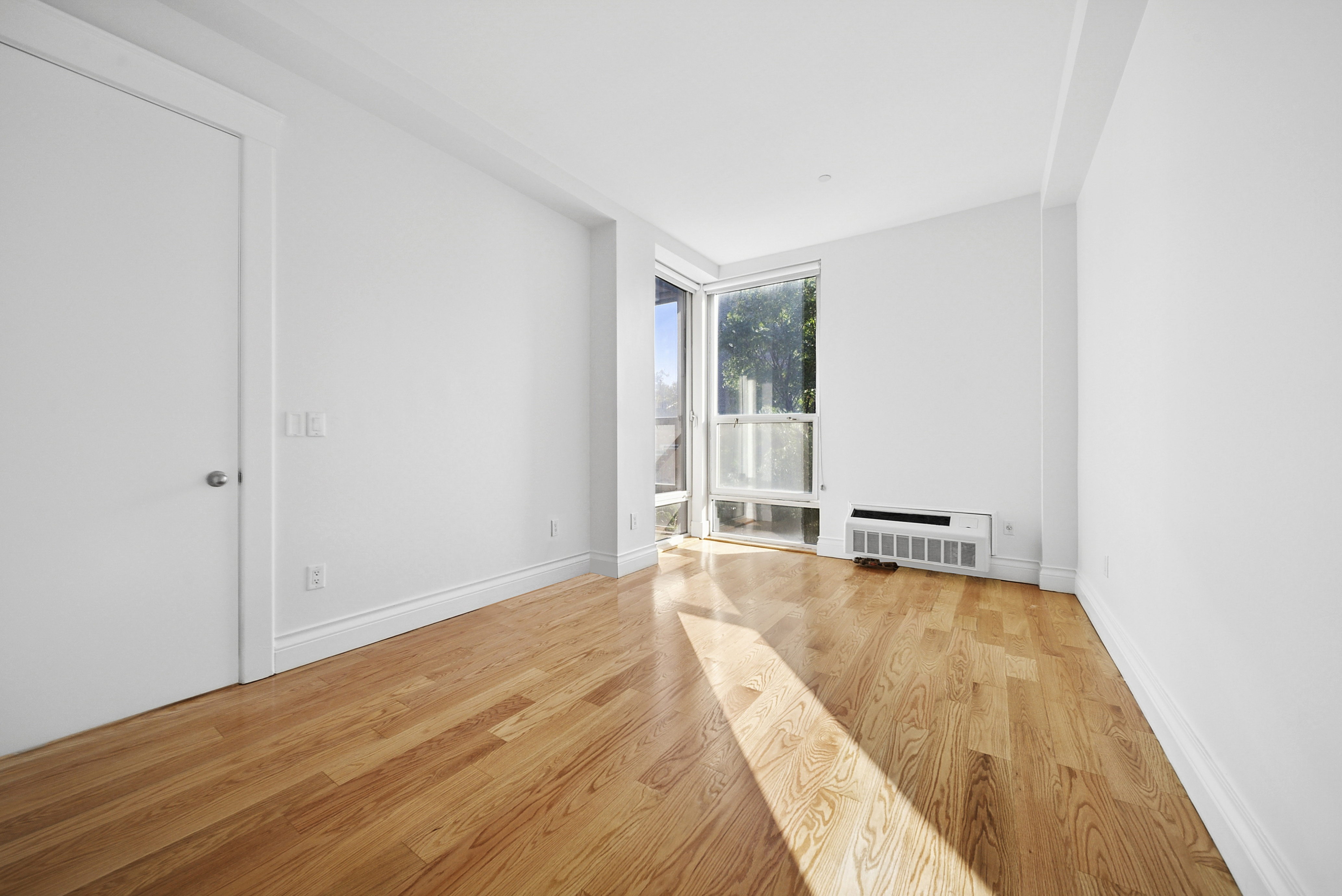480 Humboldt Street, Unit 3B Brooklyn, NY 11211 - Photo 13 of 17 a view of a room with wooden floor and a window