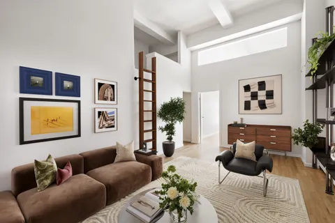 a living room with furniture and a painting on the wall