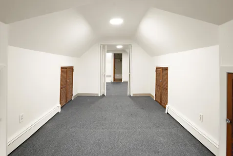 an empty room with closet and wooden door