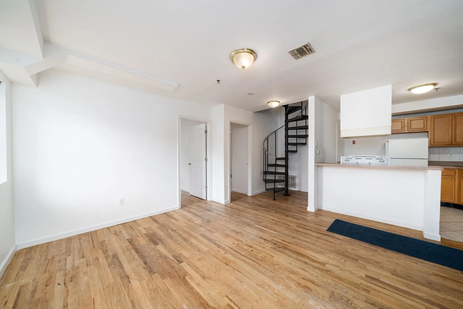 a view of a kitchen with wooden floor and a sink