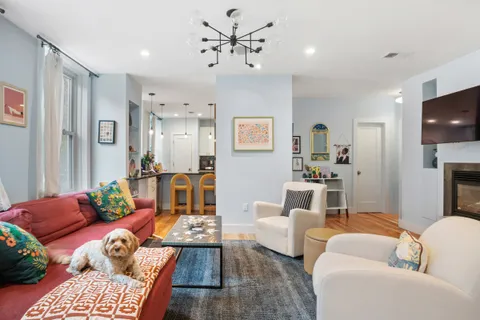 a living room with furniture ceiling fan and a flat screen tv