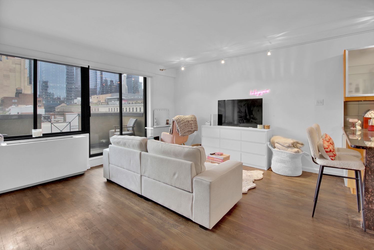 408 8th Avenue, Unit 8B Manhattan, NY 10001 - Photo 2 of 12 a living room with furniture and a flat screen tv
