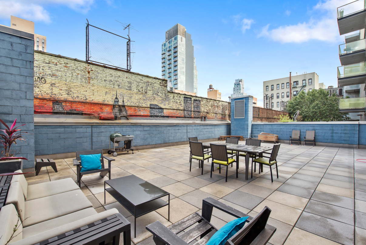 105 Norfolk Street, Unit 2A Manhattan, NY 10002 - Photo 3 of 16 a view of a roof deck with table and chairs