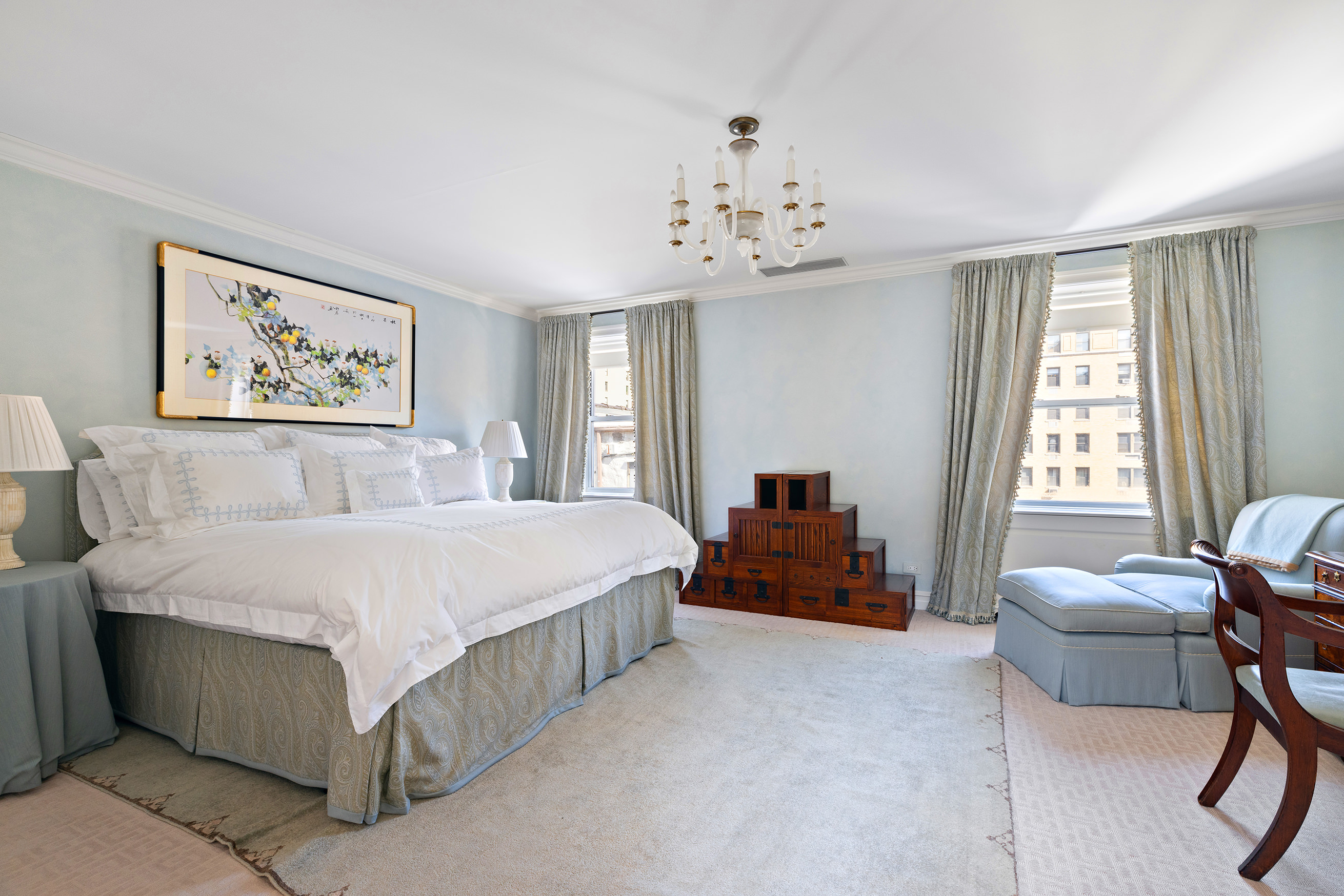 127 East 73rd Street Manhattan, NY 10021 - Photo 32 of 40 a spacious bedroom with a bed and a chandelier